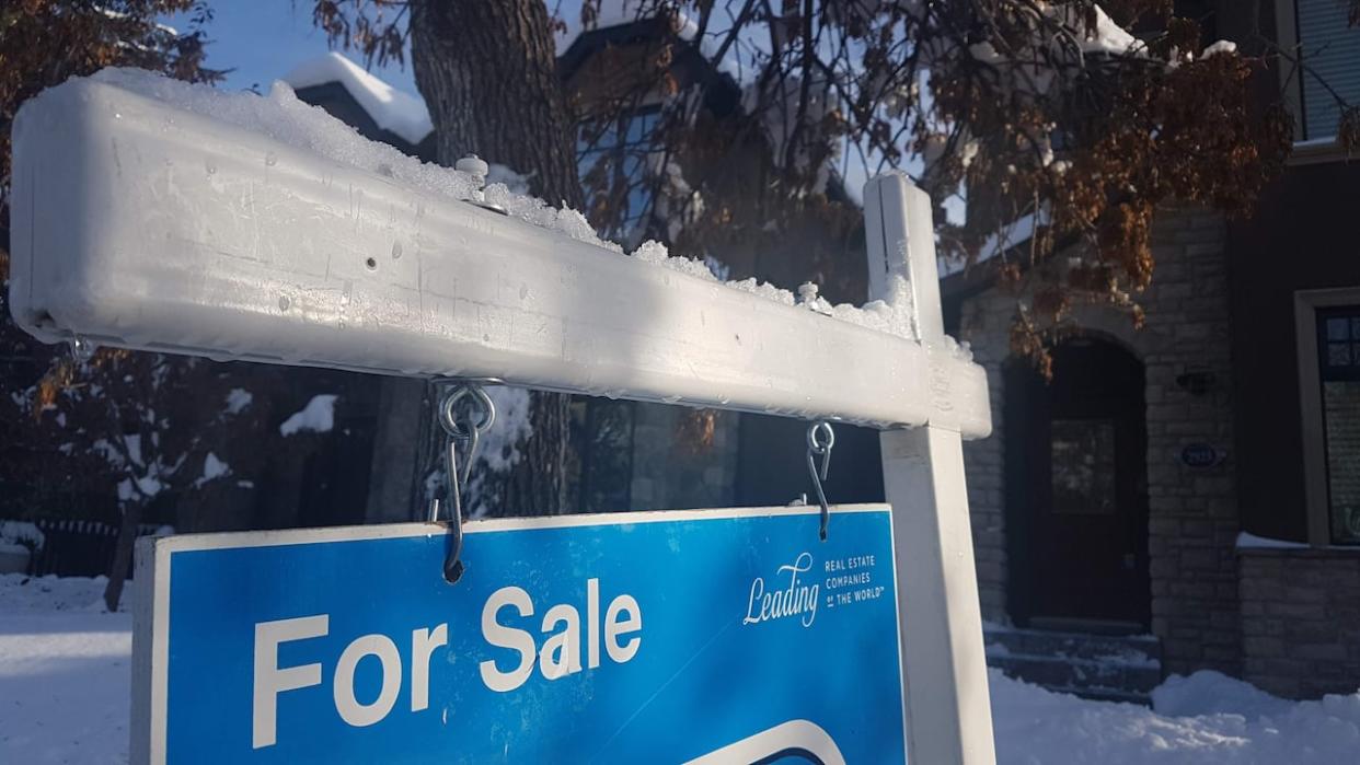 A snow-covered sign advertising a house for sale in Calgary. (Robson Fletcher/CBC - image credit)