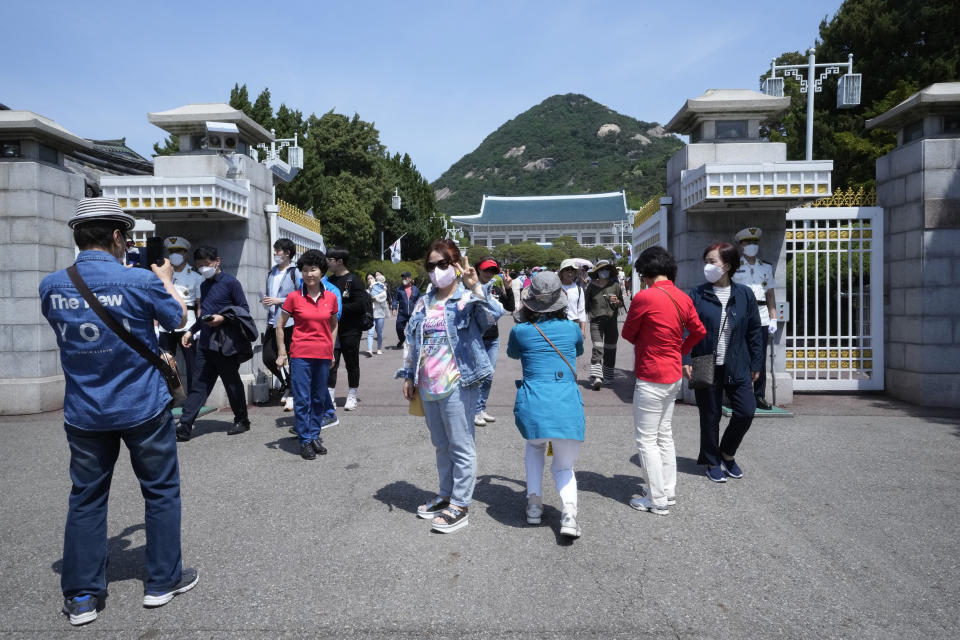 People take photos in front of the main entrance gate of the Blue House, the former presidential palace, in Seoul, South Korea, Thursday, May 12, 2022. For most South Koreans, the former presidential palace in Seoul was as shrouded in mystery as the buildings in their secretive rival North Korea. That’s now changed recently as thousands have been allowed a look inside for the first time in 74 years.(AP Photo/Ahn Young-joon)