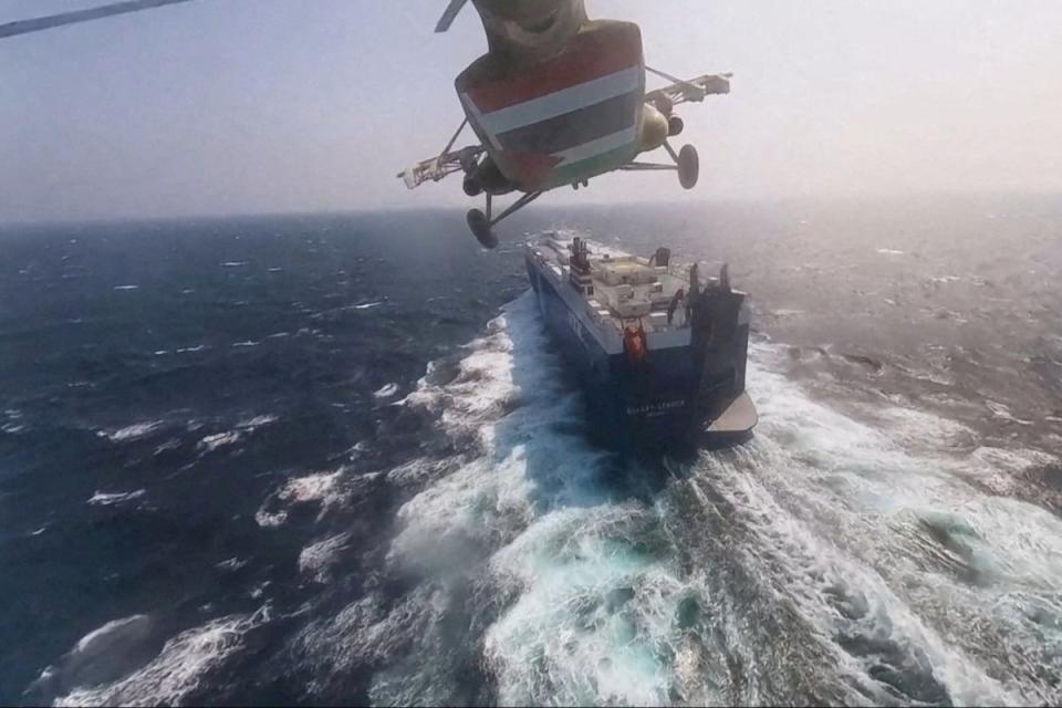 Houthi military helicopter flies over the Galaxy Leader cargo ship in the Red Sea (Reuters)