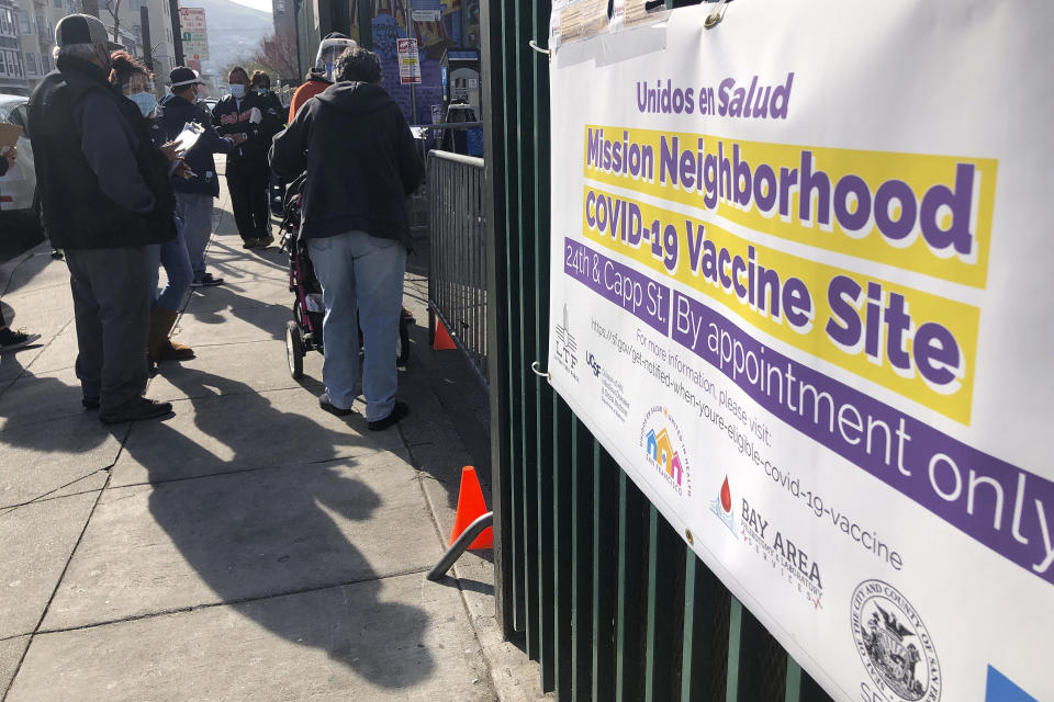 People wait in line at a COVID-19 vaccine site in the Mission district of San Francisco, Monday, Feb. 8, 2021. Counties in California and other places in the U.S. are trying to ensure they vaccinate people in largely Black, Latino and working-class communities that have borne the brunt of the coronavirus pandemic. San Francisco is reserving some vaccines for seniors in the two ZIP codes hit hardest by the pandemic. (AP Photo/Haven Daley)