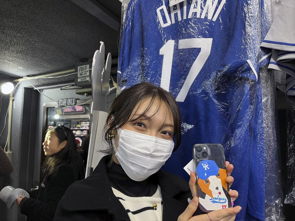 Hina Kishi shows off the Shohei Ohtani design on her smart phone as she shops on Monday Feb 26, 2024, at a sporting goods store, "SELECTION," in Shinjuku district in Tokyo. (AP Photo/Stephen Wade)