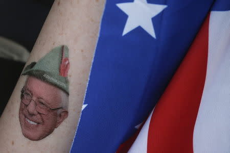 A young supporter of Bernie Sanders wears a temporary tattoo depicting Sanders as Robin Hood, outside of the venue before the start of the Univision News and Washington Post Democratic presidential candidates debate in Kendall, Florida, March 9, 2016. REUTERS/Carlo Allegri