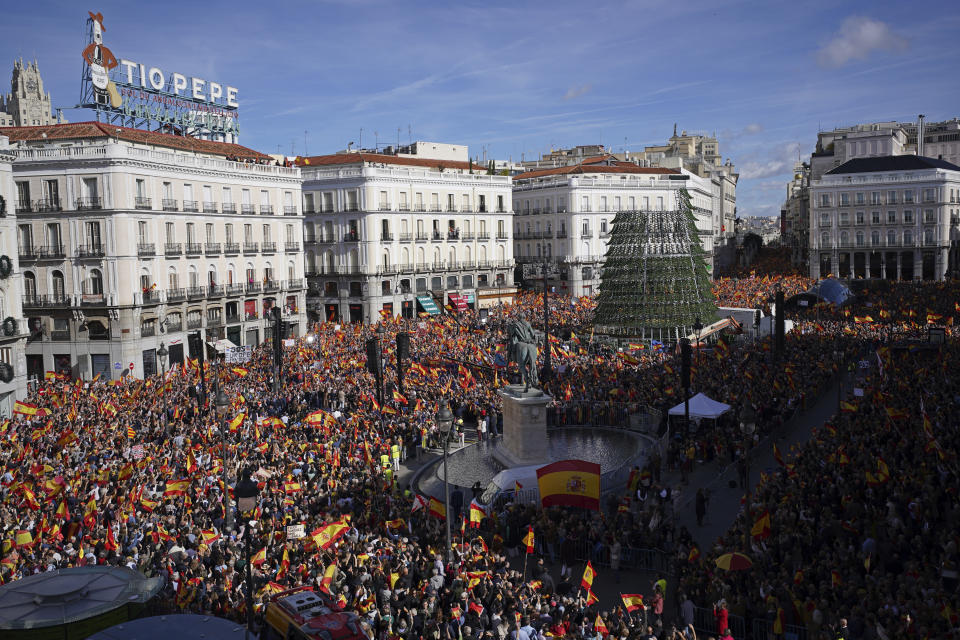 Crowds with Spanish flags pack the central Puerta del Sol during a protest called by Spain's Conservative Popular Party in Madrid, Spain, Sunday Nov.12, 2023. The Popular Party are protesting Spain's Socialists deal to grant amnesty to Catalan separatists in exchange for support of new government. (AP Photo/Joan Mateu Parra)