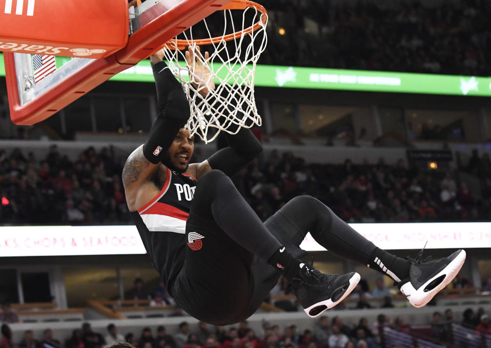 Nov 25, 2019; Chicago, IL, USA; Portland Trail Blazers forward Carmelo Anthony (00) hangs on the rim after dunking the ball against the Chicago Bulls during the second half at United Center. Mandatory Credit: David Banks-USA TODAY Sports