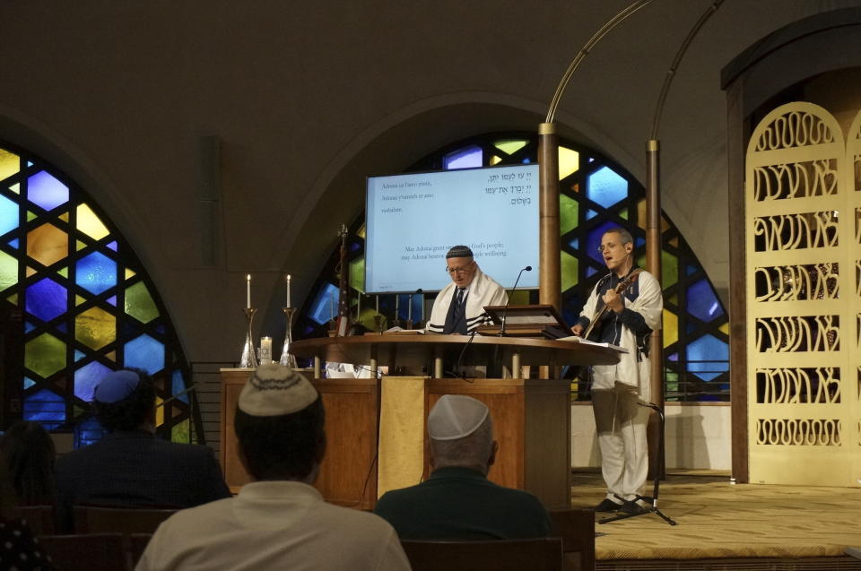 Cantor Juval Porat (right) and Rabbi Robert Davis lead Shabbat services at Temple Beth Sholom in Miami Beach, Fla., on Friday, Oct. 13, 2023. While Porat's parents hunkered down in a safe room in northern Israel, the cantor tried to focus on selecting hymns that would bring solace but also an opportunity to grieve to the 300 congregants. "For the life of me, I'm not going to cry. I need to be strong, so that other people can cry," Porat said. (AP Photo/Giovanna Dell'Orto)