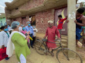 Health workers persuade Indian villager Pana Lall, 60, center, to get vaccinated against the coronavirus at Sikanderpur village, Uttar Pradesh state, India, on June 9, 2021. India's vaccination efforts are being undermined by widespread hesitancy and fear of the jabs, fueled by misinformation and mistrust. That's especially true in rural India, where two-thirds of the country’s nearly 1.4 billion people live. (AP Photo/Rajesh Kumar Singh)