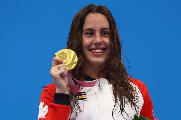 Aurélie Rivard  of Canada poses on the podium with her gold medal in the women's 100-metre freestyle. (Marko Djurica/Reuters - image credit)
