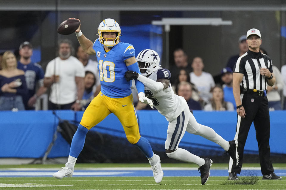 Los Angeles Chargers quarterback Justin Herbert (10) throws while under pressure from Dallas Cowboys safety Donovan Wilson (6) during the first half of an NFL football game Monday, Oct. 16, 2023, in Inglewood, Calif. (AP Photo/Mark J. Terrill)