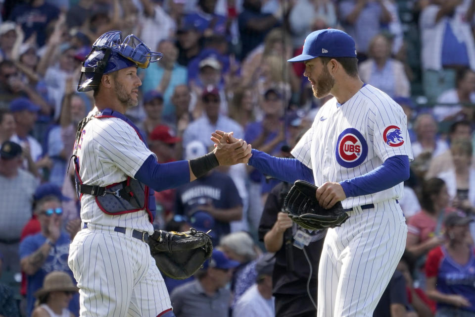 Chicago Cubs catcher Yan Gomes and relief pitcher Brandon Hughes celebrate the team's 2-0 win over the St. Louis Cardinals after a baseball game Tuesday, Aug. 23, 2022, in Chicago. (AP Photo/Charles Rex Arbogast)