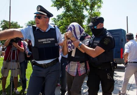 One of the eight Turkish soldiers who fled to Greece in a helicopter and requested political asylum after a failed military coup against the government, is escorted to the courthouse of the northern city of Alexandroupolis, Greece, July 21, 2016. REUTERS/Antonis Pasvantis