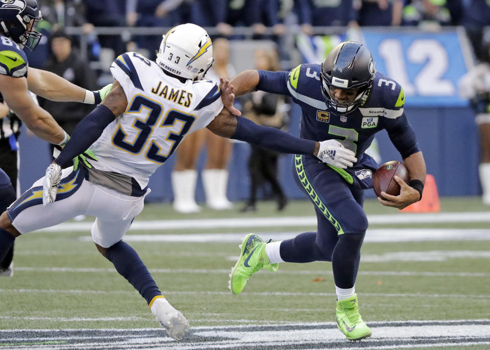 Seattle Seahawks quarterback Russell Wilson (3) scrambles away from Los Angeles Chargers' Derwin James during the second half of an NFL football game, Sunday, Nov. 4, 2018, in Seattle. (AP Photo/Ted S. Warren)