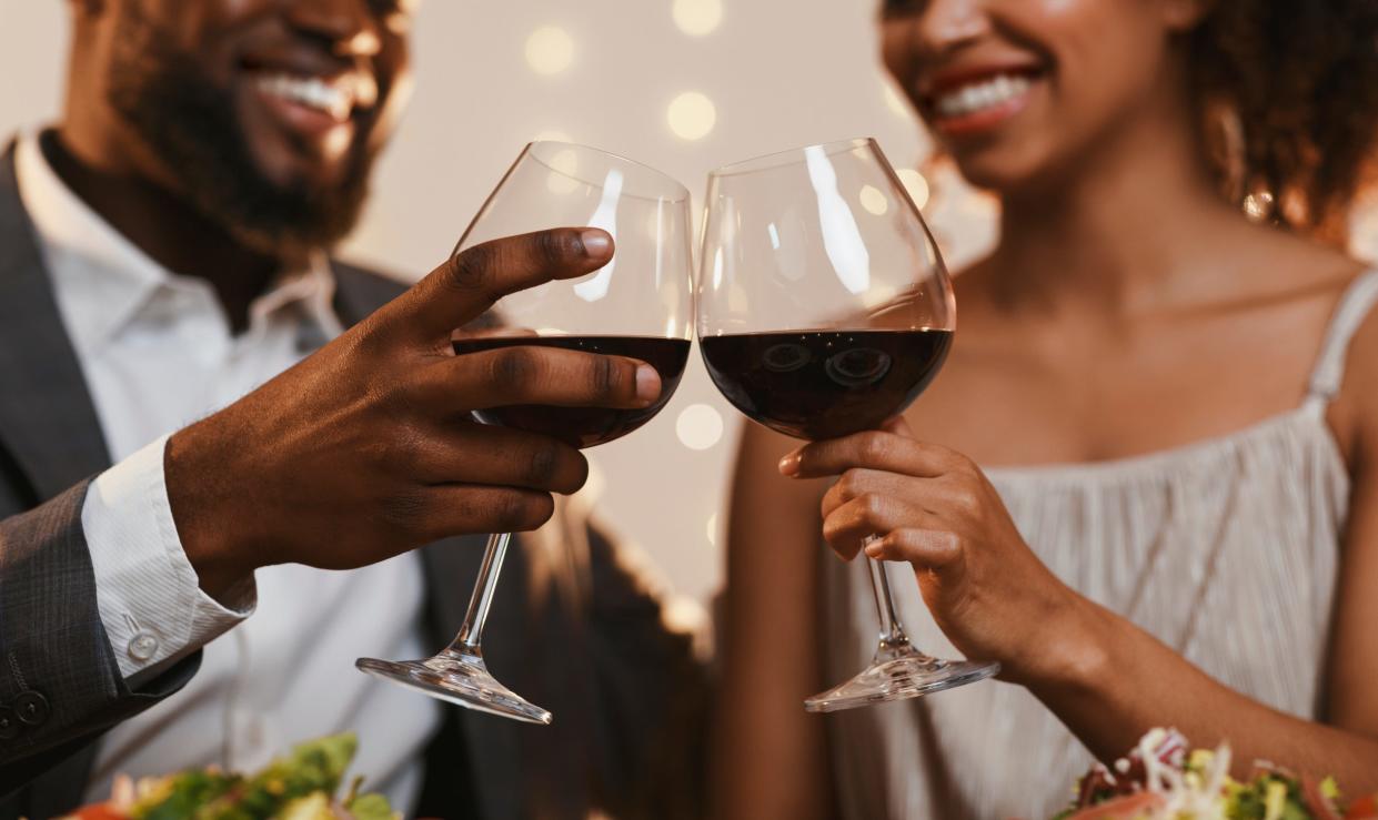 Black couple drinking red wine.