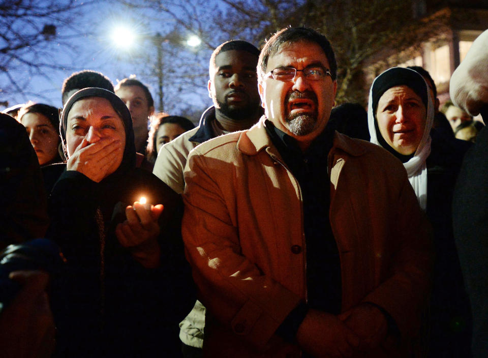 Namee Barakat, center, and his Layla, right, watch a photo presentation during a vigil for his daughters on Wednesday, Feb. 11, 2015, in Chapel Hill, N.C. Craig Stephen Hicks is accused of shooting Deah Barakat, 23, his wife Yusor Abu-Salha, 21, and Abu-Salha's sister, Razan Abu-Salha, 19, on Tuesday. (Chuck Liddy/The News & Observer/TNS via Getty Images)