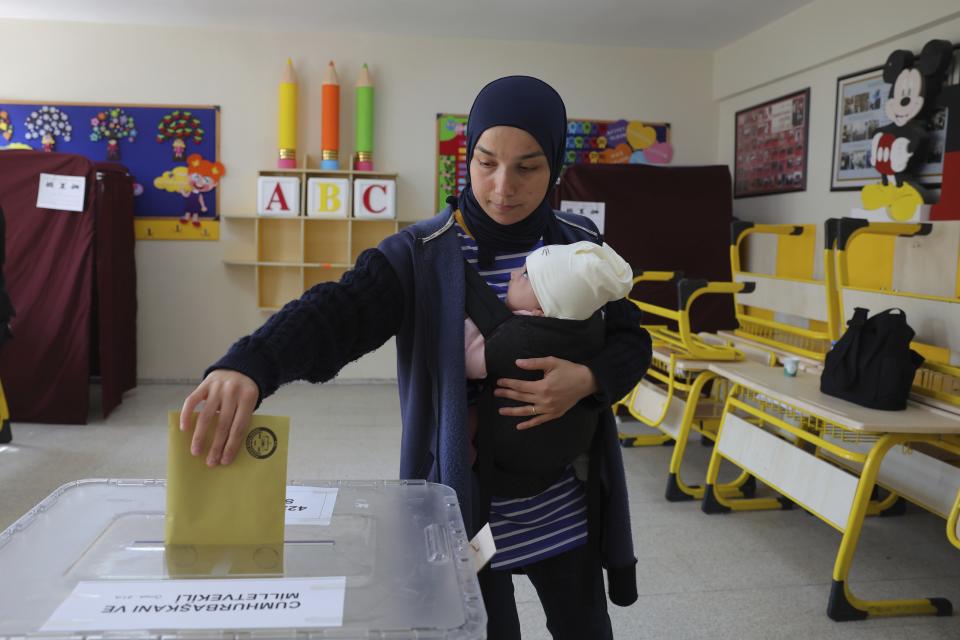A woman with a baby votes at a polling station in Ankara, Turkey, Sunday, May 14, 2023. Voters in Turkey are heading to the polls on Sunday for landmark parliamentary and presidential elections that are expected to be tightly contested and could be the biggest challenge Turkish President Recep Tayyip Erdogan faces in his two decades in power. (AP Photo)