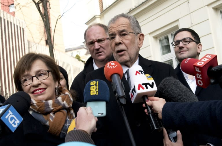 Alexander Van der Bellen, candidate for presidential election and his wife Doris Schmidauer (L) talk to journalists as they leave the polling station on December 4, 2016