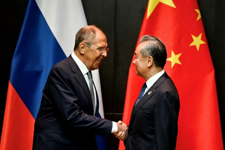 Russia's Foreign Minister Sergei Lavrov (left) shakes hands with his Chinese counteropart Wang Yi on the sidelines of the ASEAN meeting in Vientiane (TANG CHHIN Sothy)