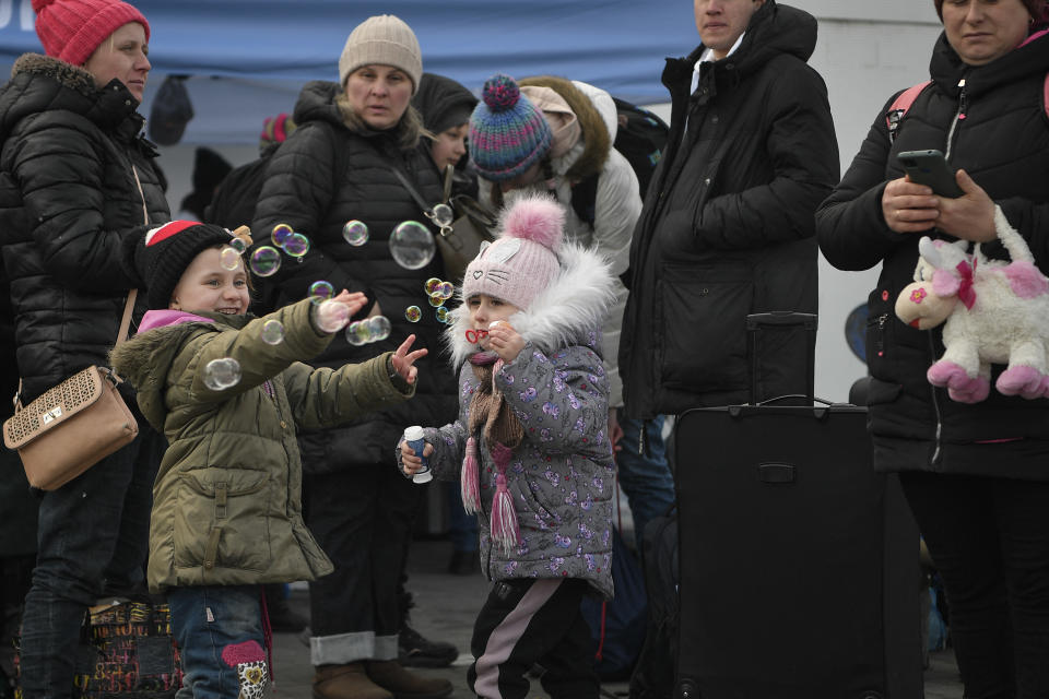 Children play as they wait for buses to transfer them to Germany from the temporary shelter for refugees located in a former shopping center between the Ukrainian border and the Polish city of Przemysl, in Poland, on March 08, 2022. (Photo by Louisa GOULIAMAKI / AFP) (Photo by LOUISA GOULIAMAKI/AFP via Getty Images)