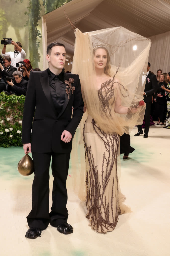 Sean in suit with floral accent, Lana in a sheer, embroidered gown with a veil