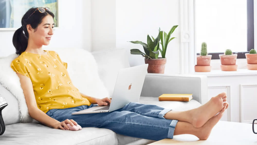  A woman sits on a sofa while using one of the best USB-C mouse options 