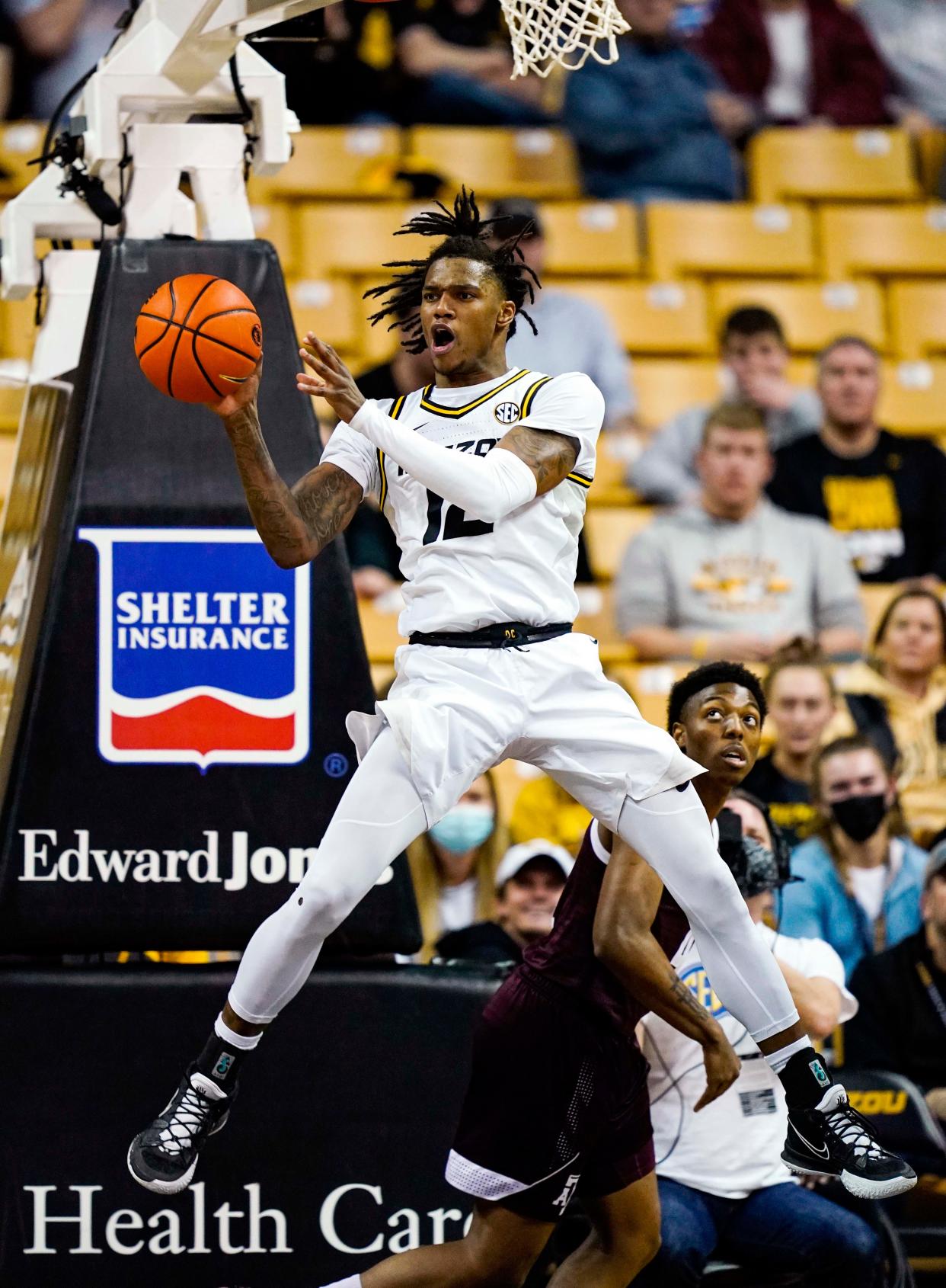 Missouri guard DaJuan Gordon (12) saves the ball as Texas A&M guard Wade Taylor IV (4) defends during a game Saturday at Mizzou Arena.