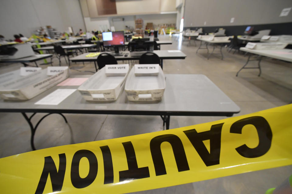 Cobb County Election officials prepare for a recount, Tuesday, Nov. 24, 2020, in Marietta, Ga. County election workers across Georgia have begun an official machine recount of the roughly 5 million votes cast in the presidential race in the state. The recount was requested by President Donald Trump after certified results showed him losing the state to Democrat Joe Biden by 12,670 votes, or 0.25% (AP Photo/Mike Stewart)