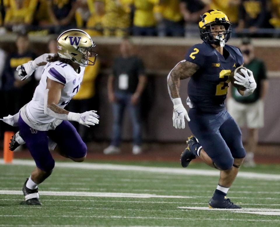 Michigan Wolverines running back Blake Corum (2) runs by Washington Huskies defensive back Kamren Fabiculanan (31) for a touchdown Saturday, Sept. 11, 2021 at Michigan Stadium.