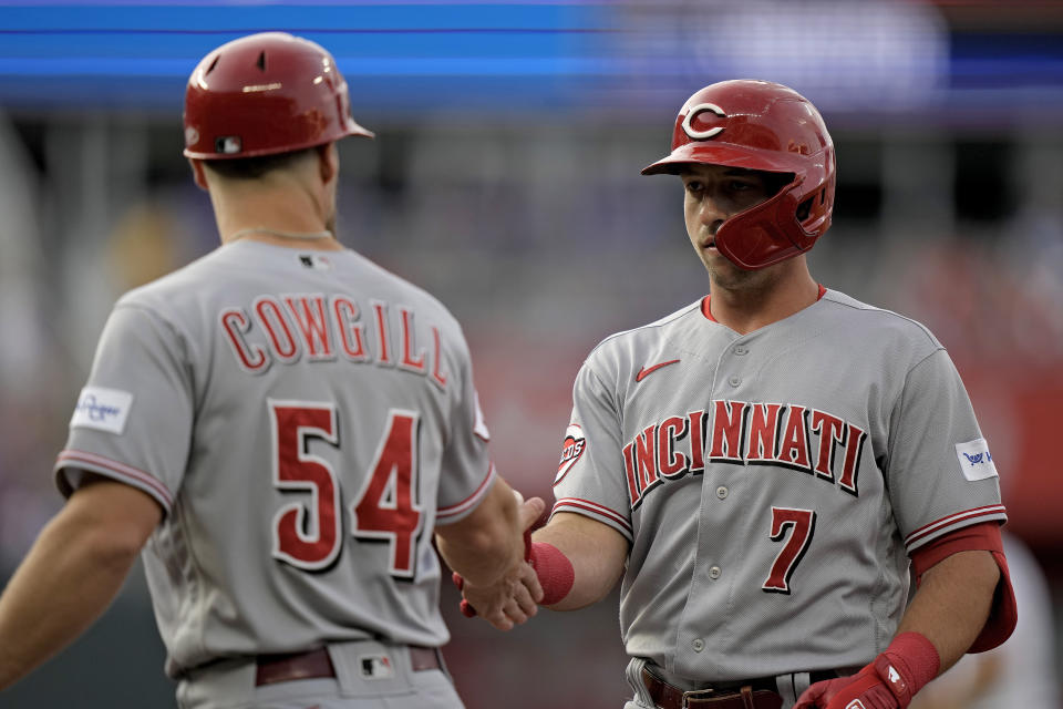 Cincinnati Reds' Spencer Steer (7) celebrates with first base coach Collin Cowgill (54) after hitting an RBI single during the second inning of a baseball game against the Kansas City Royals Tuesday, June 13, 2023, in Kansas City, Mo. (AP Photo/Charlie Riedel)