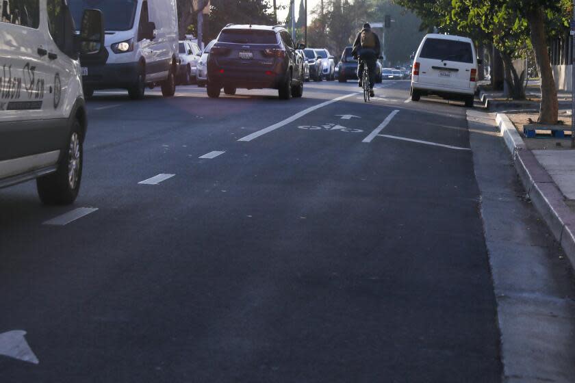 Los Angeles, CA - December 12: A man drives in the bike lane on the busy intersection of Edgemont and Fountain Ave on Tuesday, Dec. 12, 2023 in Los Angeles, CA. (Michael Blackshire / Los Angeles Times)