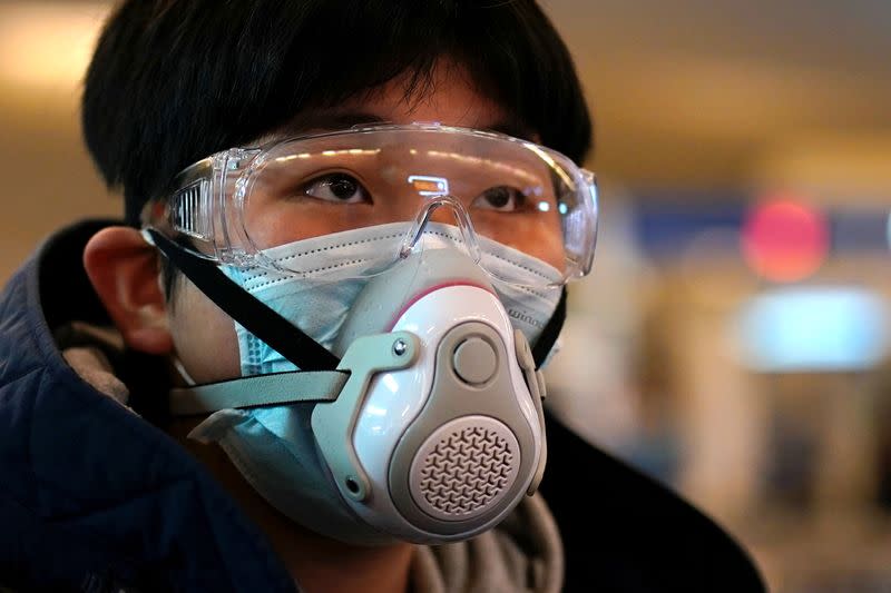 A passenger wearing a protective mask arrives at a railway station in Wuhan