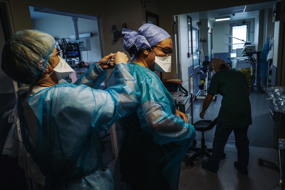 Una enfermera ayuda a una compañera a colocarse el equipo de protección antes de entrar en una habitación para atender a un paciente infectado de Covid-19. (Foto: Lucas Barioulet / AFP / Getty Images).