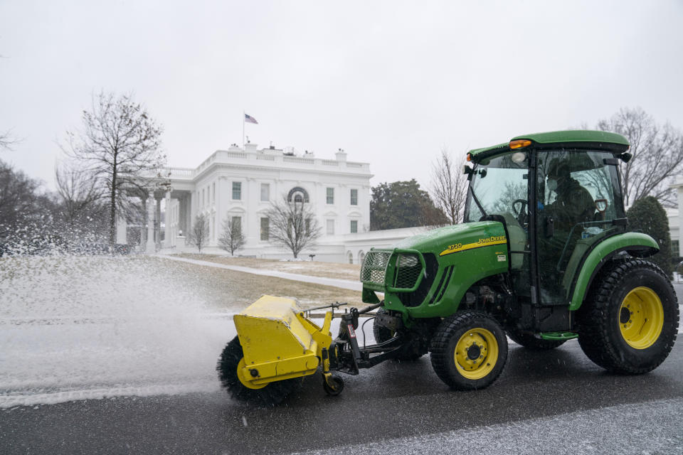 Workers from the National Park Service clear snow and ice at the White House, Thursday, Feb. 18, 2021, in Washington. (AP Photo/Evan Vucci)