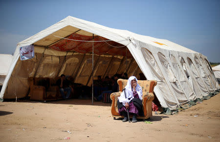 A Palestinian woman sits near the Israel-Gaza border during a tent city protest, in the southern Gaza Strip April 2, 2018. REUTERS/Ibraheem Abu Mustafa