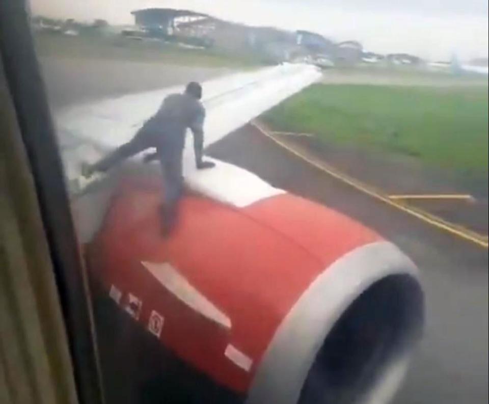 A man has been filmed climbing on to the wing of a passenger plane before takeoff, reportedly causing panic among passengers.In dramatic footage taken from inside the aircraft the man is seen hauling himself up from the rim of the jet engine onto the wing of the Boeing 737 plane and then walking towards the cabin.The incident occurred on an Azman Air flight in Lagos, Nigeria. The aircraft was reportedly at a holding bay expecting clearance for take-off when the man was seen climbing onto the wing, according to the News Agency of Nigeria (Nan).The agency said it was not known how the man had apparently managed to “illegally” gain access to the aircraft, although the Murtala Muhammed Airport in Lagos has suffered from problems with security in the past.The man’s actions reportedly caused a panic and some of the passengers demanded the pilot and cabin crew open the aircraft doors for them to disembark due to safety concerns.The general manager for corporate affairs at the Federal Airports Authority of Nigeria, Henrietta Yakubu, confirmed the incident had taken place and said the man had been arrested.> Man climbs onto wing of Azman Air 737 at Lagos airport as it prepares for takeoff. https://t.co/LwkjRaFsey pic.twitter.com/xXuLJXlGw8> > — Breaking Aviation News (@breakingavnews) > > July 19, 2019She said the stowaway was arrested by security officers and was taken to Tango City, a security unit within the airport.A spokesperson for the Lagos Airport Police Command, Joseph Alabi, also confirmed the incident to the Nan news agency.A “reliable source” told Nan the man, upon arrest, claimed he wanted to travel to Ghana but refused to disclose how he managed to gain access to the restricted airside.
