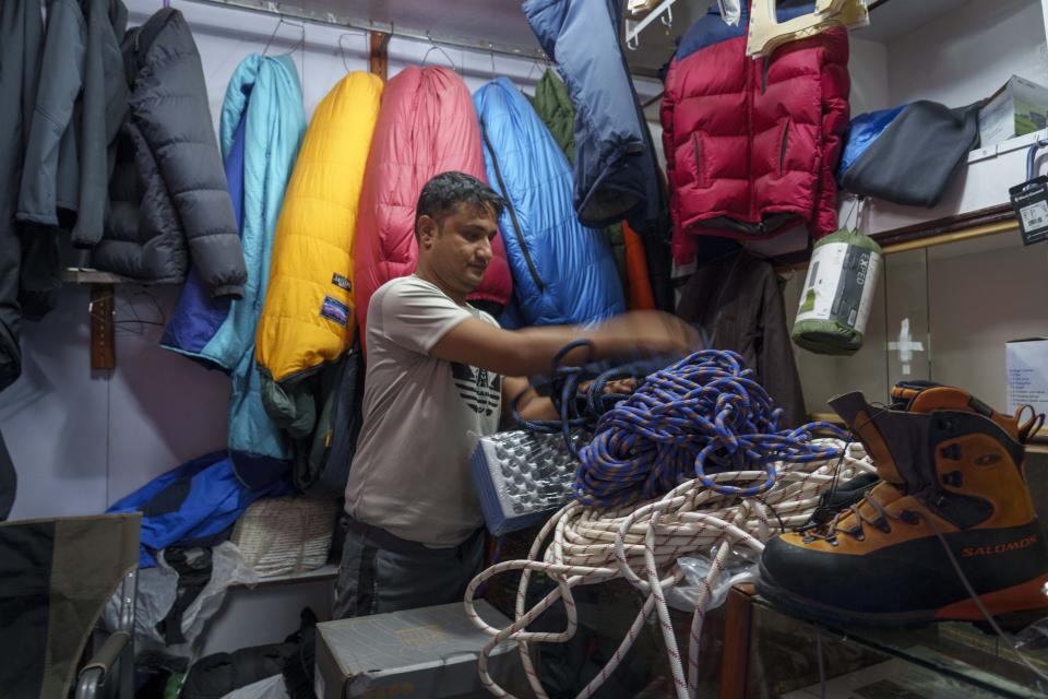 A vendor at a trekking gear store adjusts the rope used for climbing at the Thamel tourist hub in Kathmandu, Nepal, Thursday, May 25, 2023. Nepal is getting ready to mark the 70th anniversary of the first ascent of Mount Everest in 1953 by New Zealander Edmund Hillary and his Sherpa guide Tenzing Norgay. (AP Photo/Niranjan Shrestha)