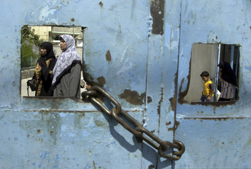 <p>Palestinians leave a United Nations health clinic, with its main vehicle gate chained closed, at the Jabalia refugee camp, home to over 101,000 refugees, in the northern Gaza Strip, Aug. 20, 2002. (Photo: Jacqueline Larma/AP) </p>