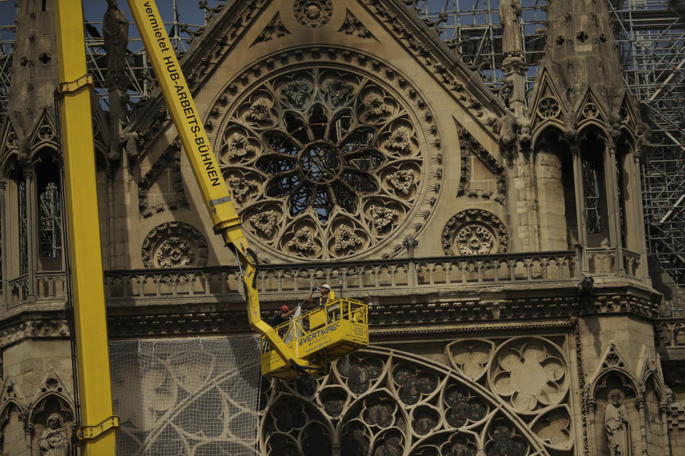 Workers fix a net to cover one of the iconic stained glass windows of the Notre Dame Cathedral in Paris, Sunday, April 21, 2019. The fire that engulfed Notre Dame during Holy Week forced worshippers to find other places to attend Easter services, and the Paris diocese invited them to join Sunday's Mass at the grandiose Saint-Eustache Church on the Right Bank of the Seine River. (AP Photo/Francisco Seco)