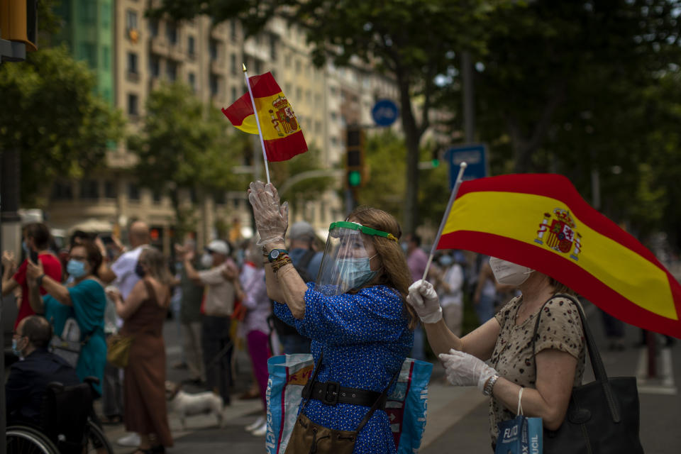 People applaud at demonstrators during a drive-in protest organised by Spain's far-right Vox party against the Spanish government's handling of the nation's coronavirus outbreak in Barcelona, Spain, Saturday, May 23, 2020. (AP Photo/Emilio Morenatti)