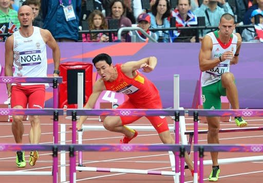 Atleta chino China Liu Xiang (C) cae en los 110 metros llanos en los Juegos Olímpicos de Londres 2012 el 7 de agosto de 2012. (AFP | gabriel bouys)