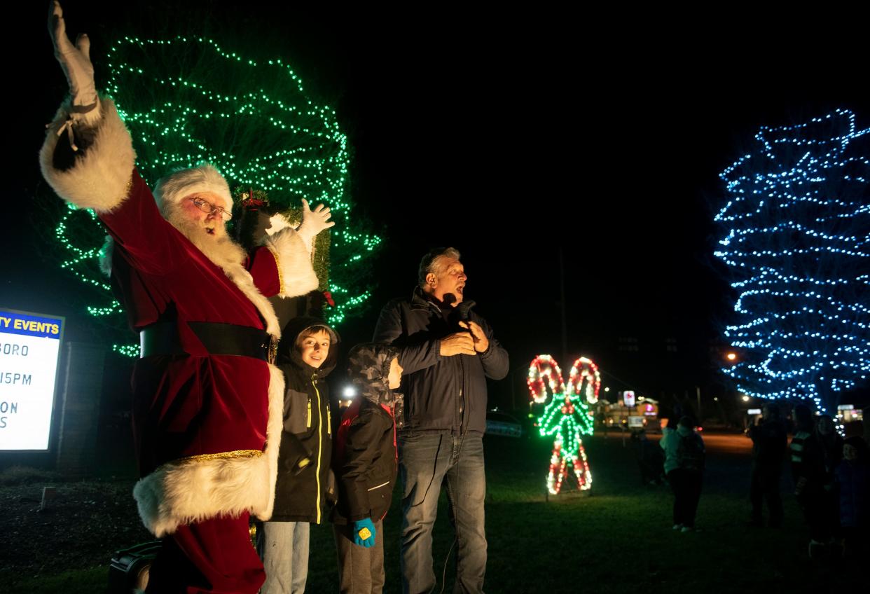 Santa and Streetsboro Mayor Glenn Broska, with help from brothers Dusty Greathouse, 10, and Jerimiah Greathouse, 8, turn on the Christmas lights Thursday night at Streetsboro's Public Square.