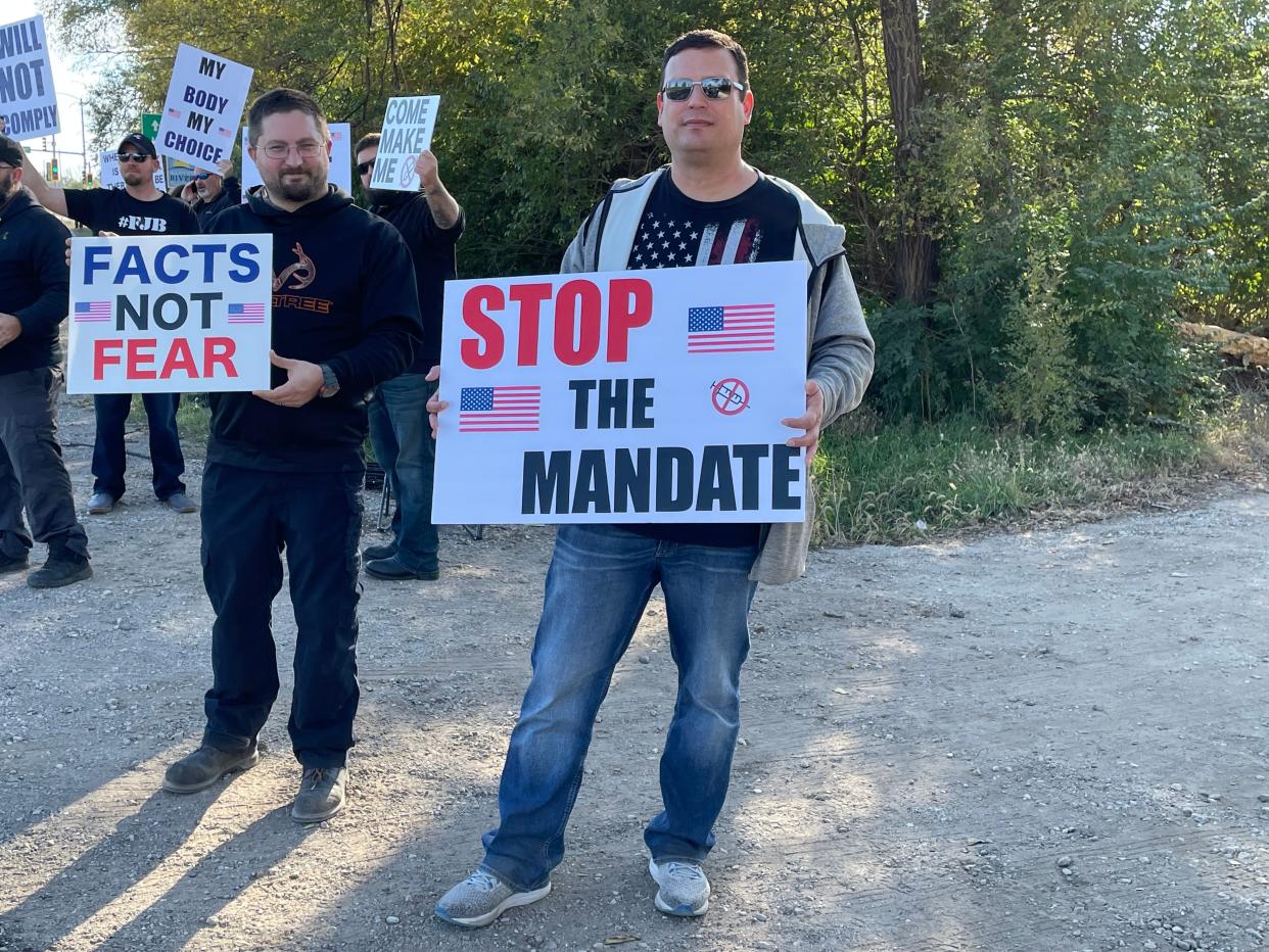 FCI Pekin employees Jeff Frank (left) and Thomas Kamm (right) demonstrate outside the facility Monday afternoon.