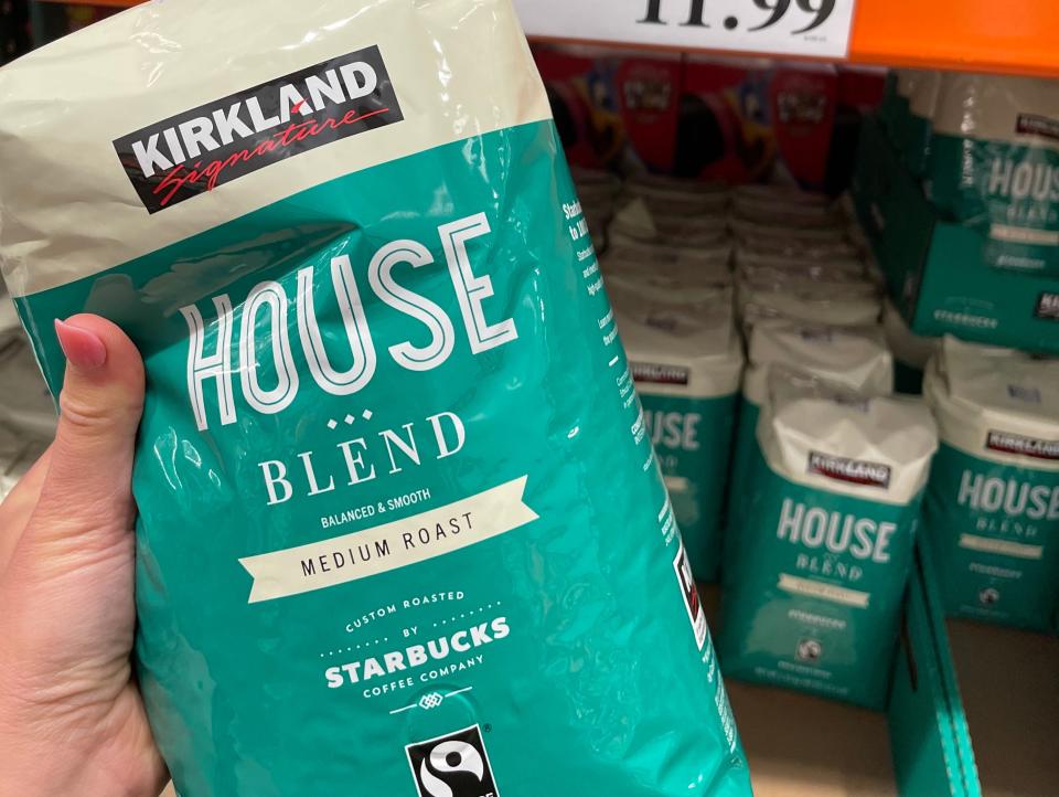 hand holding beige and teal bag of coffee at costco