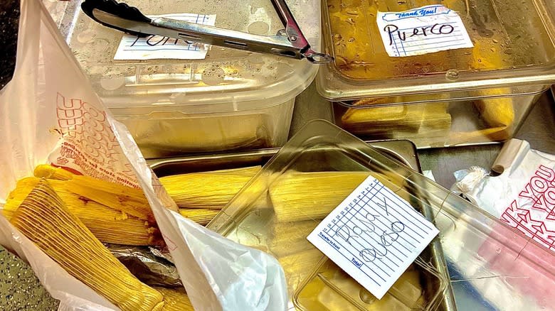 tubs of tamales with tongs