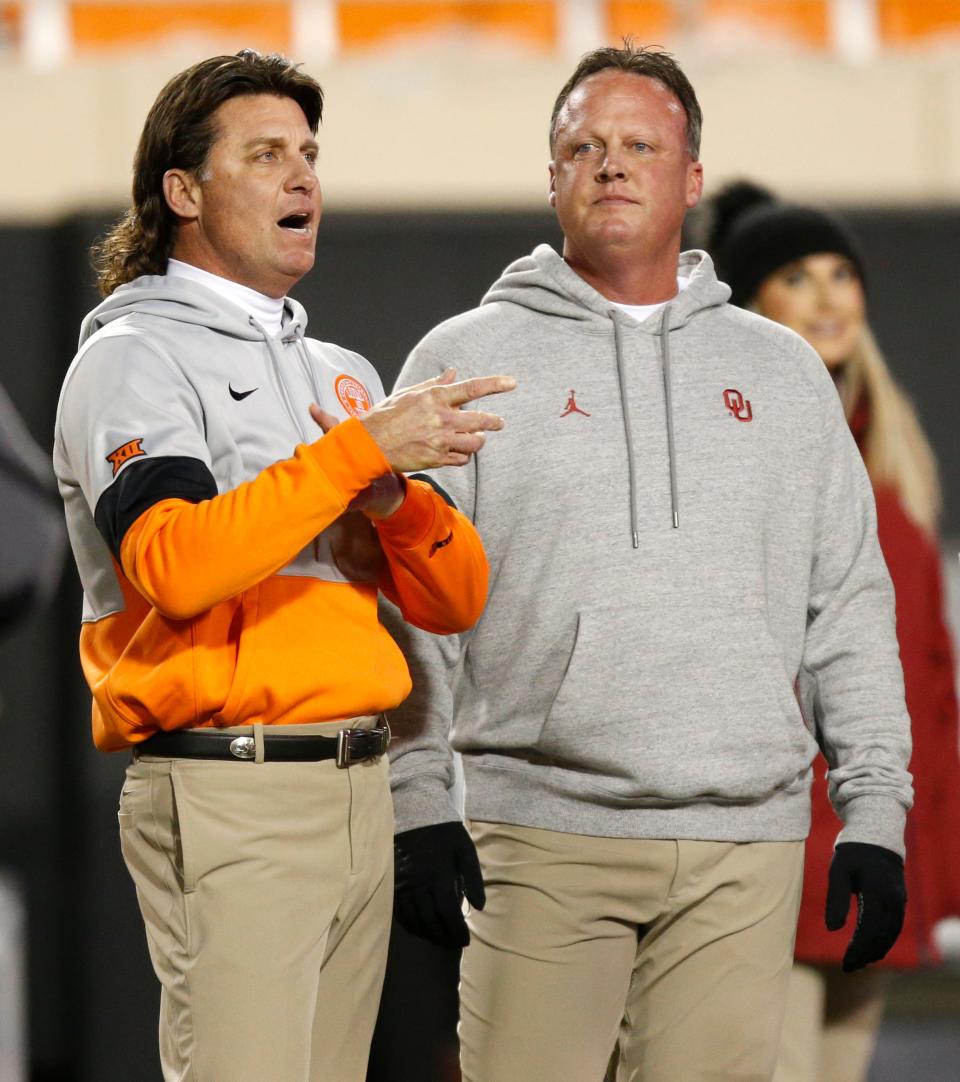 OSU coach Mike Gundy, left, talks with his brother, then-OU assistant coach Cale Gundy, before the 2019 Bedlam football game in Stillwater.