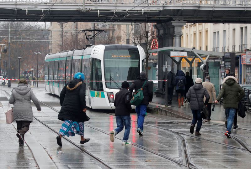 Passengers wait for a tramway during a nationwide strike by French SNCF railway workers in Paris