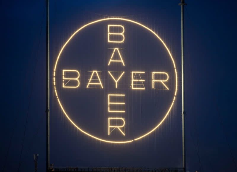 The Bayer Cross, the company's logo, shines on the Bayer site in Leverkusen. Thomas Banneyer/dpa