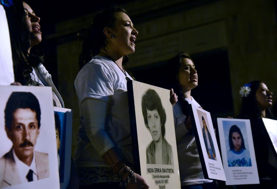 Women hold pictures of people who went missing during the armed conflict, during a march for peace in Bogota, on October 20, 2016.