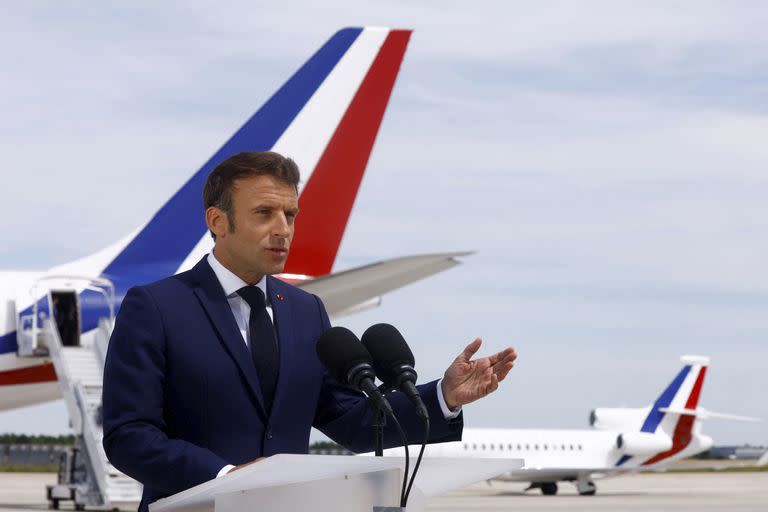 El presidente francés Emmanuel Macron hace declaraciones en la pista frente a su avión presidencial antes de partir a una visita a tropas francesas de la OTAN en Rumania, en el aeropuerto de Orly, martes 14 de junio de 2022. (Gonzalo Fuentes/Pool via AP)