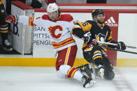 Pittsburgh Penguins' Jason Zucker (16) and Calgary Flames' Brett Ritchie (24) collide during the first period of an NHL hockey game in Pittsburgh, Thursday, Oct. 28, 2021. (AP Photo/Gene J. Puskar)