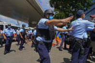 Police officers maintain orders as a 23-year-old man, Tong Ying-kit, arrives at a court in Hong Kong Monday, July 6, 2020. Tong has become the first person in Hong Kong to be charged under the new national security law, for allegedly driving a motorcycle into a group of policemen while bearing a flag with the "Liberate Hong Kong, revolution of our time" slogan. (AP Photo/Vincent Yu)