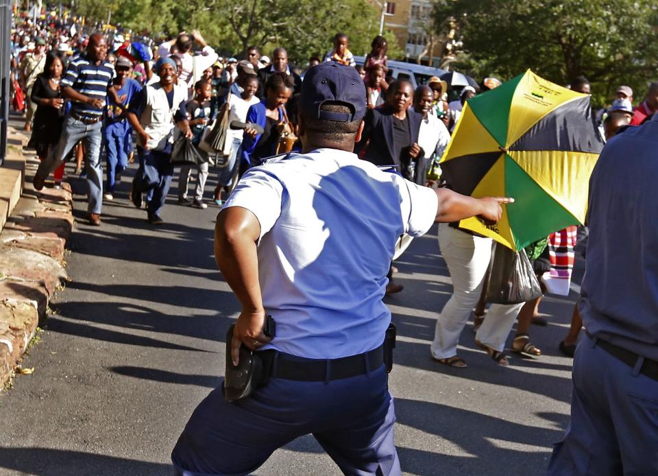 A police officer gestures as mourners attempt to walk to the Union Buildings to view the body of former South African President Nelson Mandela in Pretoria